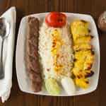 Combination Of One Skewer Of Koobideh Kebab And One Skewer Of Joojeh Kebab, Served With Basmati Rice And Roasted Tomato.
